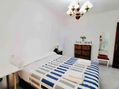 a bedroom with a bed and a chandelier at Mar Vendaval Grupo AC Gestion in Cádiz