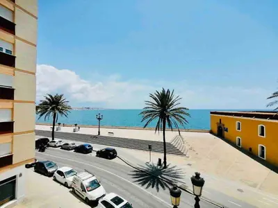 a view of a parking lot with palm trees and the ocean at Mar Vendaval Grupo AC Gestion in Cádiz