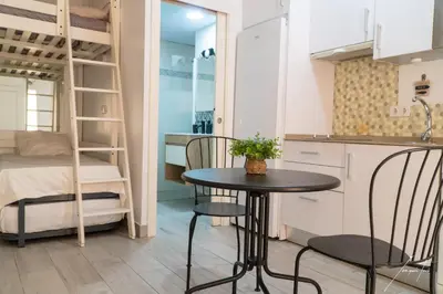 a small table and chairs in a small room with a bunk bed at Puerto Sherry Boat in El Puerto de Santa María