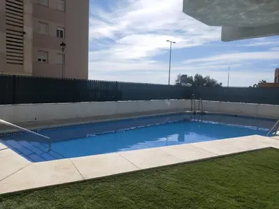 a swimming pool on the side of a building at Wehostcostaluz -Apartamento El Parador in El Puerto de Santa María