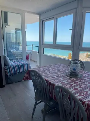 a dining room with a table and a view of the ocean at Wehostcostaluz -Apartamento El Parador in El Puerto de Santa María