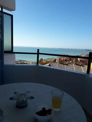 a table with a bowl of fruit and a glass of orange juice at Wehostcostaluz -Apartamento El Parador in El Puerto de Santa María