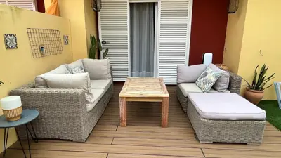 a patio with two wicker chairs and a coffee table at Sanlúcar Bajo de Guía PG Apartamentos in Sanlúcar de Barrameda