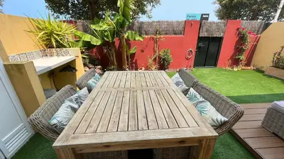 a wooden table and chairs in a backyard at Sanlúcar Bajo de Guía PG Apartamentos in Sanlúcar de Barrameda