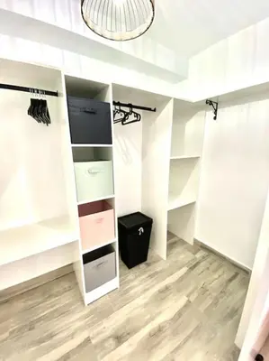 a walk in closet with white shelves and a chandelier at Apartamento en el centro San Fernando Cadiz. in San Fernando