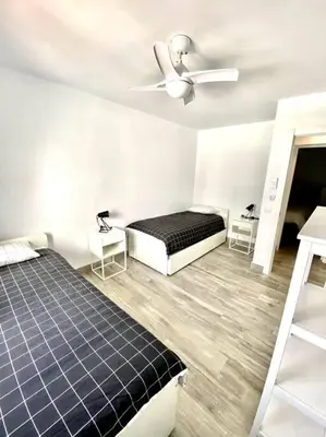 a bedroom with two beds and a ceiling fan at Apartamento en el centro San Fernando Cadiz. in San Fernando