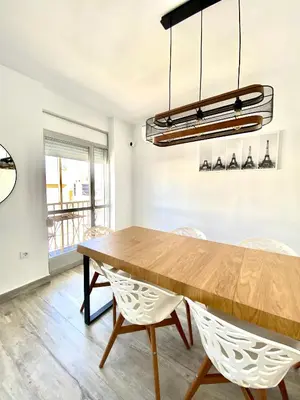 a dining room with a wooden table and chairs at Apartamento en el centro San Fernando Cadiz. in San Fernando