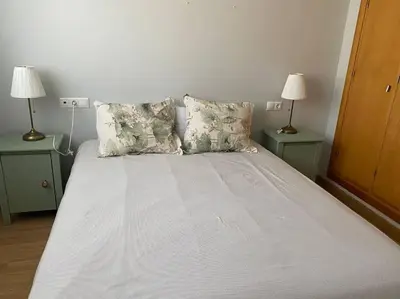 a bedroom with a bed with two nightstands and two lamps at Apartamento primera linea de playa reformado en Las Redes in El Puerto de Santa María