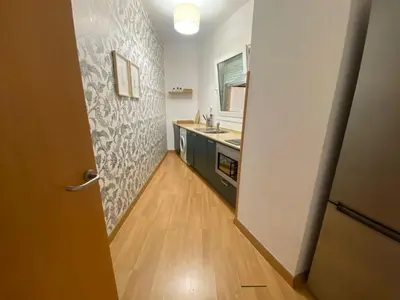 a room with a kitchen with a sink and a door at Apartamento primera linea de playa reformado en Las Redes in El Puerto de Santa María