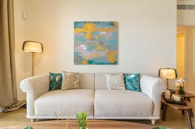 a white couch in a living room with a painting at Allo Apartments Bonald Parking Piscina 3 Habitaciones in Jerez de la Frontera