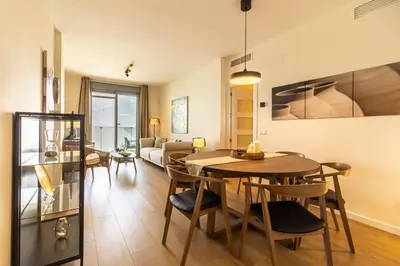 a dining room and living room with a table and chairs at Allo Apartments Bonald Parking Piscina 3 Habitaciones in Jerez de la Frontera