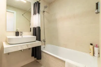 a white bathroom with a sink and a bath tub at Allo Apartments Bonald Parking Piscina 3 Habitaciones in Jerez de la Frontera