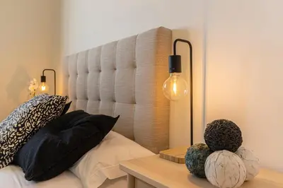 a bedroom with a large headboard and a table with pumpkins at Allo Apartments Bonald Parking Piscina 3 Habitaciones in Jerez de la Frontera
