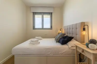a bedroom with a bed with a window and a desk at Allo Apartments Bonald Parking Piscina 3 Habitaciones in Jerez de la Frontera