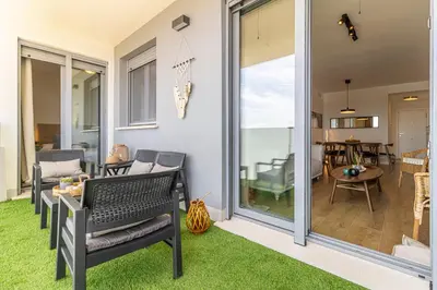 a patio with a table and chairs on the grass at Allo Apartments Bonald Parking Piscina 3 Habitaciones in Jerez de la Frontera