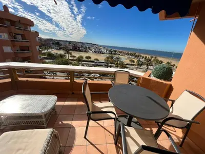 a balcony with a table and chairs and a view of the beach at Mirador de Sanlucar 6 in Sanlúcar de Barrameda