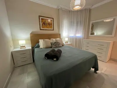 a bedroom with a bed with two night stands and two lamps at Mirador de Sanlucar 6 in Sanlúcar de Barrameda