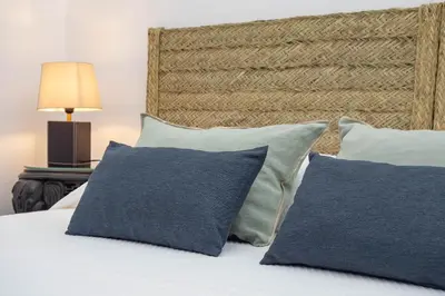 a bedroom with a bed with blue pillows at La Casa 1832 Boutique in Sanlúcar de Barrameda