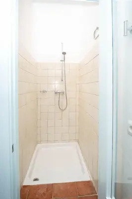 a bathroom with a shower with a white tub at La Casa 1832 Boutique in Sanlúcar de Barrameda