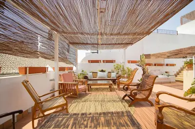 a patio with chairs and a table on a deck at La Casa 1832 Boutique in Sanlúcar de Barrameda