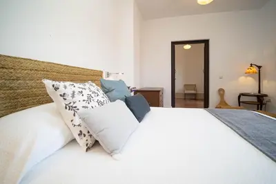 a bedroom with a white bed with pillows at La Casa 1832 Boutique in Sanlúcar de Barrameda
