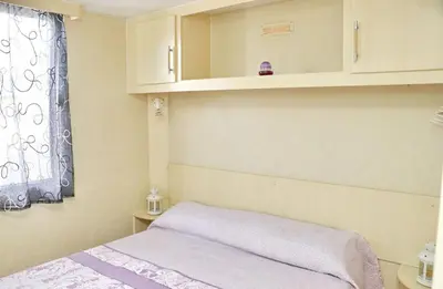 a small bedroom with a bed and a window at Bungalow Puntalejo in Conil de la Frontera