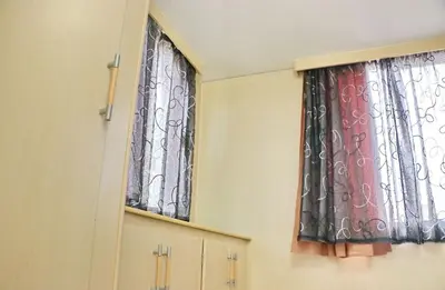 two windows with curtains in a room at Bungalow Puntalejo in Conil de la Frontera