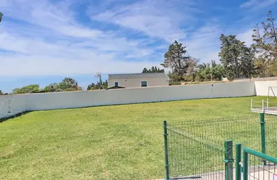 a fence in front of a soccer field at Bungalow Puntalejo in Conil de la Frontera