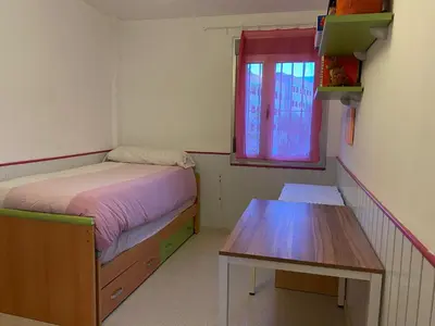 a small bedroom with a bed and a table at Casa Ohana in Conil de la Frontera