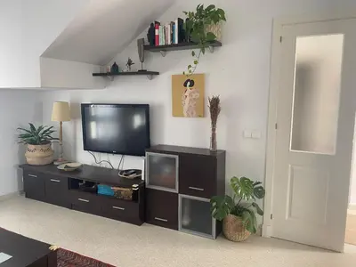 a living room with a flat screen tv on a entertainment center at Casa Ohana in Conil de la Frontera
