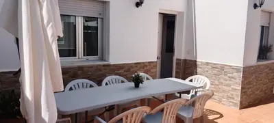 a white table and chairs on a patio at Casa Ohana in Conil de la Frontera