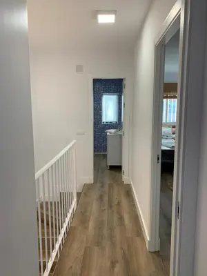 a hallway with white walls and wooden floors in a house at Apartamento en la Barrosa in Chiclana de la Frontera