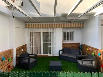 a living room with two couches and green grass at Apartamento en la Barrosa in Chiclana de la Frontera