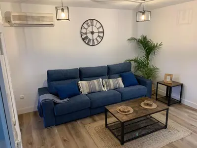 a blue couch in a living room with a table at Apartamento en la Barrosa in Chiclana de la Frontera