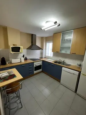a kitchen with blue cabinets and a counter top at Ático Costa Ballena - Cádiz in Rota