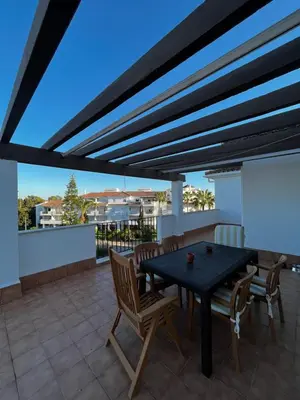 a patio with a table and chairs on a roof at Ático Costa Ballena - Cádiz in Rota