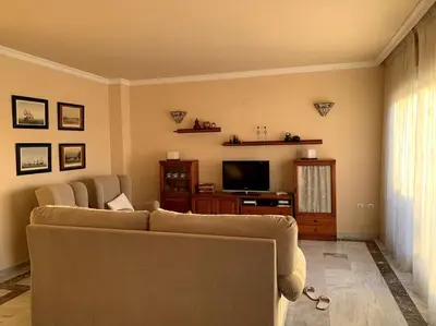 a living room with a couch and a television at Ático Costa Ballena - Cádiz in Rota