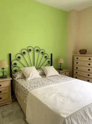 a bedroom with a large bed and two night stands at Ático Costa Ballena - Cádiz in Rota