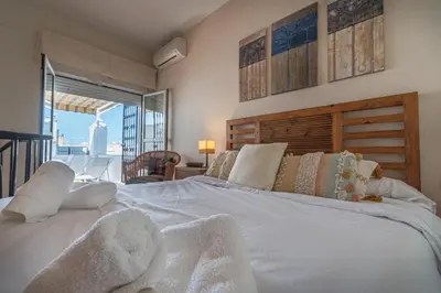 a large white bed in a room with a window at Terraza Estampa de Cádiz in Cádiz