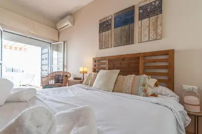 a large white bed in a room with a window at Terraza Estampa de Cádiz in Cádiz