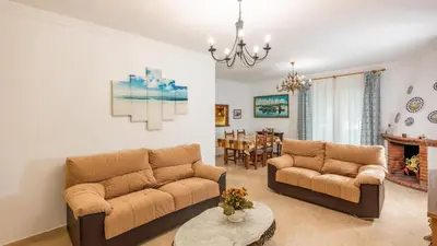 a living room with two couches and a dining room at Villa Las Carmenes Conil de la Frontera by Ruralidays in Conil de la Frontera