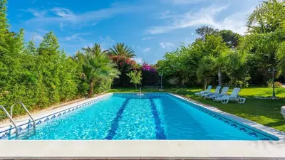 a swimming pool in a yard with palm trees at Villa Las Carmenes Conil de la Frontera by Ruralidays in Conil de la Frontera