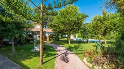 a garden with palm trees and a walkway at Villa Las Carmenes Conil de la Frontera by Ruralidays in Conil de la Frontera
