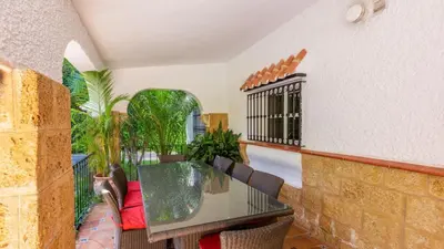a balcony with a glass table and chairs at Villa Las Carmenes Conil de la Frontera by Ruralidays in Conil de la Frontera