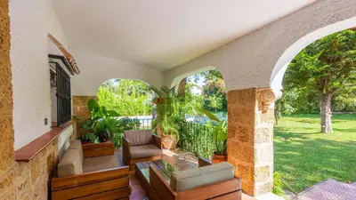 a porch of a house with a couch and chairs at Villa Las Carmenes Conil de la Frontera by Ruralidays in Conil de la Frontera