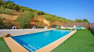 a swimming pool in a yard with two chairs at Cortijo de Liche Arcos de la Frontera by Ruralidays in Arcos de la Frontera