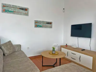 a living room with a couch and a flat screen tv at Villa Nostos - Ole Solutions in Cádiz