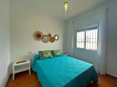 a bedroom with a blue bed and a window at Villa Nostos - Ole Solutions in Cádiz