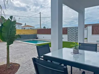 a patio with a table and chairs and a pool at Villa Nostos - Ole Solutions in Cádiz
