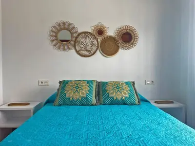 a bedroom with a bed with blue sheets and mirrors at Villa Nostos - Ole Solutions in Cádiz